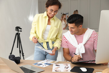 Canvas Print - Professional retoucher with colleague working at desk in photo studio