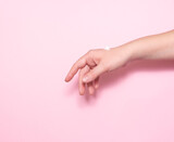 Fototapeta Kwiaty - Women's hands with skin moisturizer on a pink background. Self-care, cosmetology.