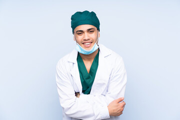 Wall Mural - Surgeon man with uniform isolated on blue background laughing