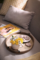 Canvas Print - Tray with flowers in cup and delicious cookies on sofa indoors