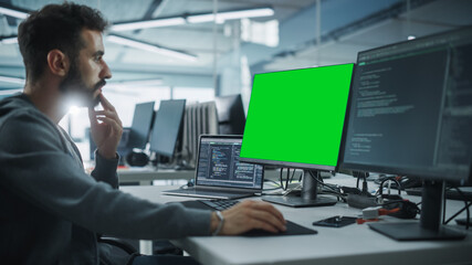 Leinwandbilder - Multi-Ethnic Office: White IT Programmer Working on Computer with Green Screen Chroma Key Display. Male Software Engineer Developing App, Program, Video Game. Terminal with Code Language.