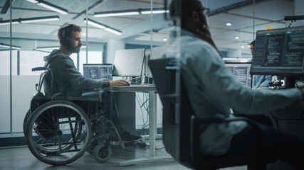 Disability-Friendly Office: Amazing IT Programmer with Disability in a Wheelchair Working on Desktop Computer. Male Specialist Create Inspirational Software. Engineer Develop Innovative App, Program