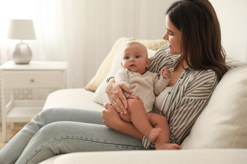 Poster - Young woman with her little baby on sofa at home