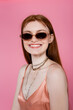 © LIGHTFIELD STUDIOS - Portrait of stylish freckled woman in sunglasses isolated on pink