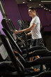 © Elena - young man works out in the gym on an elliptical trainer