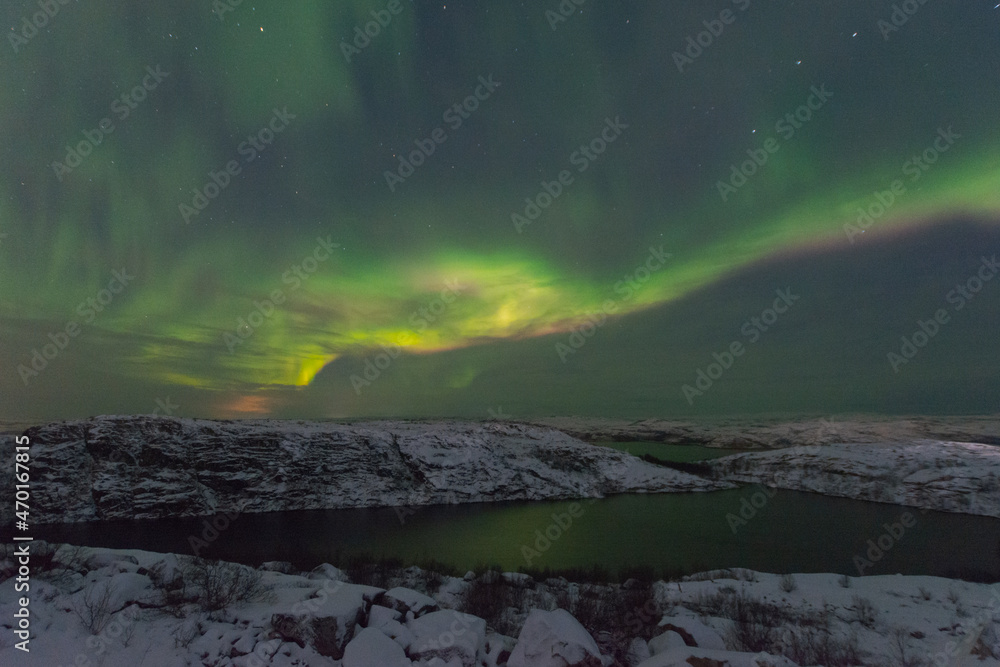Rocks and a lake in winter, the northern lights in the sky. Stock Photo ...