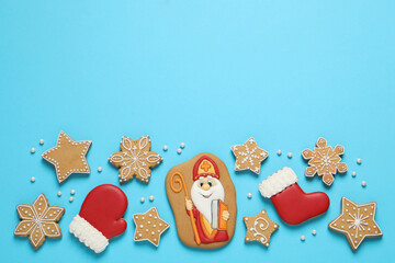 Wall Mural - Tasty gingerbread cookies on light blue background, flat lay with space for text. St. Nicholas Day celebration