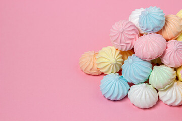 Wall Mural - Multicolored meringues on a pink background. A pile of meringues on a bright background, there is a place for copy space