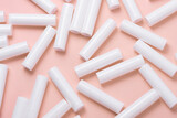 Fototapeta Lawenda - Lot of white plastic lip gloss tubes on pink background