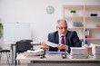 © Elnur - Aged male employee and too much work at workplace