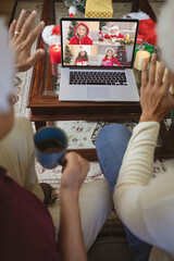 Poster - Two waving men making laptop christmas group video call with four happy caucasian girls