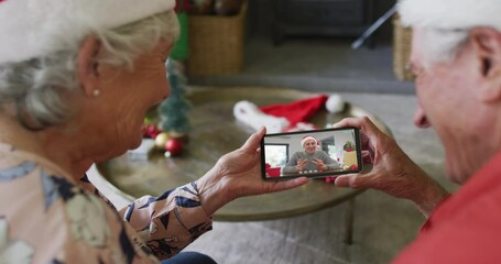 Sticker - Senior caucasian couple using smartphone for christmas video call with happy man on screen