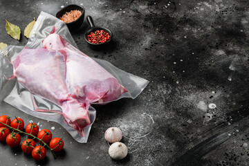 Wall Mural - Fresh turkey legs vacuum pack with ingredients, with copy space for text, on black dark stone table background