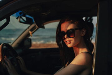 cheerful woman in sunglasses driving a car trip travel