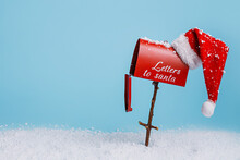 Santa's Red Mailbox With Snow Isolated On Bright Blue Background. Letters To Santa With Xmas Wishes. Creative New Year And Christmas Concept. Minimal Winter December Holiday Banner With Copy Space.