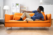 © Andrey Popov - African American Man Relaxing On Sofa
