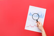 Woman with magnifier and business charts on red background
