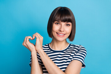 Sticker - Photo of charming happy affectionate woman hold fingers heart shape isolated on pastel blue color background