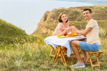 Canvas Print - Happy young couple having romantic picnic in mountains