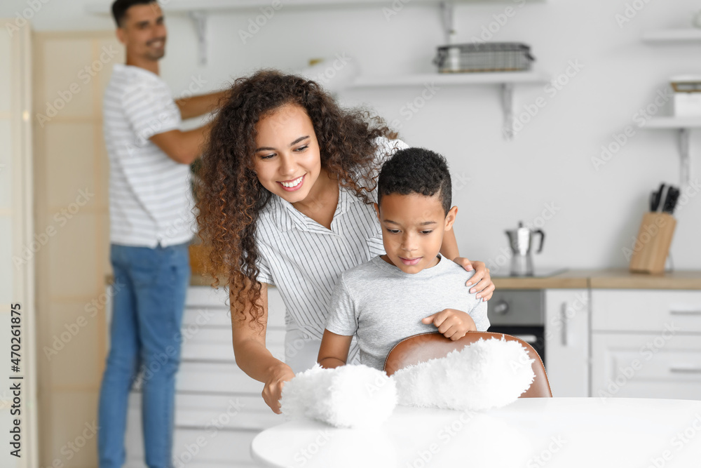 Happy interracial family cleaning kitchen
