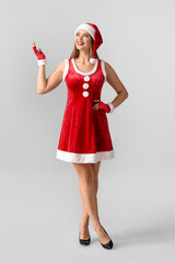 Wall Mural - Beautiful young woman in Santa costume on grey background