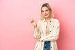 © luismolinero - Young caucasian woman isolated on pink background pointing finger to the side