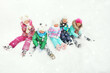 © Evgeniy Kalinovskiy - a group of preschool children in bright multi-colored winter clothes sit on the snow and smile against the background of snowfall. Christmas holidays, winter entertainment.