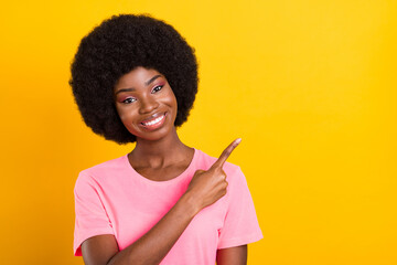 Poster - Photo of young african girl happy positive smile point finger empty space ad advice isolated over yellow color background