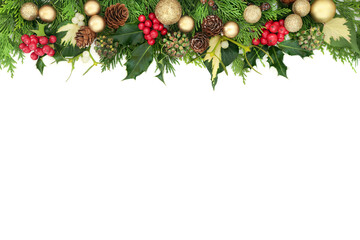 Wall Mural - Christmas background border with gold bauble decorations, holly, mistletoe, cedar and ivy on white background. Flat lay, top view, copy space.