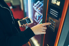 Woman Paying For Product At Vending Machine Using Smartphone