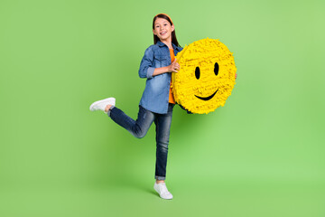 Sticker - Full body photo of cute small girl hold big toy wear shirt jeans footwear isolated on green background