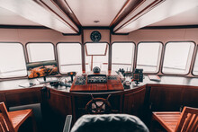 An Orlop Deck Area Inside Of A Deckhouse Of A Safari Yacht Or A Boat With A Control Panel On The Wooden Base And Many Navigation Devices: Compass, Radio Transceiver, Radars, Surveillance, Dashboards