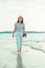 Wall Mural - woman in white clothes walking by sea beach