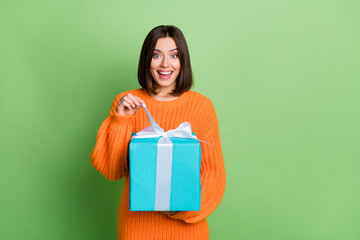 Poster - Portrait of attractive amazed funny cheerful girl opening giftbox rest event party isolated over vivid green color background