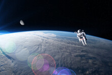 View Of An Astronaut In Extravehicular Activity With The Earth And The Moon In The Background. Photo Montage. Elements Of This Image Furnished By NASA.