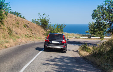 Wall Mural - Car Moves Along Winding Road to the Sea