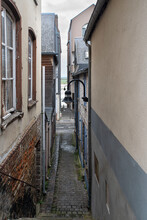 Narrow Passage Between Old Houses With A View Of The Sea In The Distance
