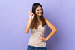 © luismolinero - Young caucasian woman isolated on purple background showing ok sign with fingers