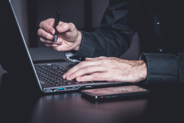 Wall Mural - Businessman using a smartphone and notebook in a moddy office