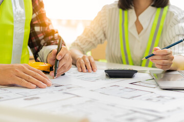 Engineers and architects are helping to design blueprints and jointly analyze the structure of the project type of the engineering team meeting and planning the construction. ideas for teamwork