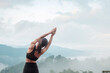 © Jo Panuwat D - Young woman doing Yoga and stretching muscle in morning, healthy girl meditation against mountain view. wellness, fitness, Vitality, exercise and work life balance concepts