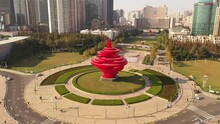 November 21, 2021 - Qingdao, China: May Fourth Wind Sculpture In May Fourth Square. Skyscrapers And Sun In The Background