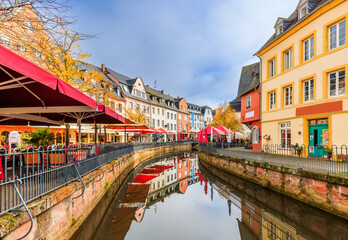 Wall Mural - Saarburg, Germany. City center with terraces and coffee shops over the river.