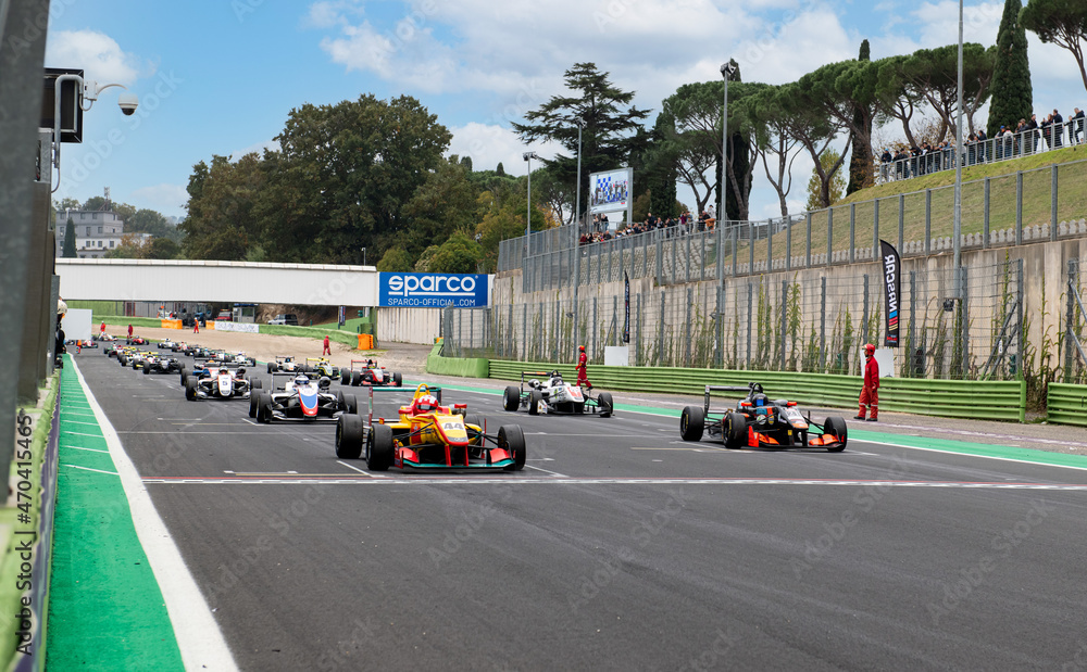 Race starting grid with aligned formula cars on straight racetrack