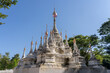 View of ancient white stupa with multiple spires and golden finials outside Wat Tham Chiang Dao cave buddhist temple, Chiang Dao, Chiang Mai, Thailand