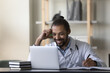 © fizkes - Smiling African American man doctor intern using laptop, looking at screen watching webinar, taking notes, professional physician practitioner writing in medical journal, filling documents