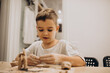 © Petro - Cute boy forming toys from clay