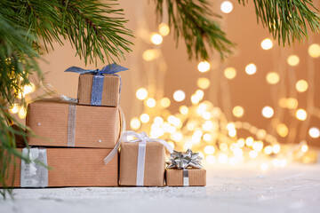 Wall Mural - Stacks of Christmas gift boxes laid under a Christmas tree with defocused lights. Handmade surprise presents. New year holiday concept.