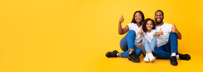 Wall Mural - Excited African people gesturing thumbs up sitting on floor, panorama