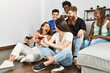 © Krakenimages.com - Group of young friends smiling happy playing video game at home.